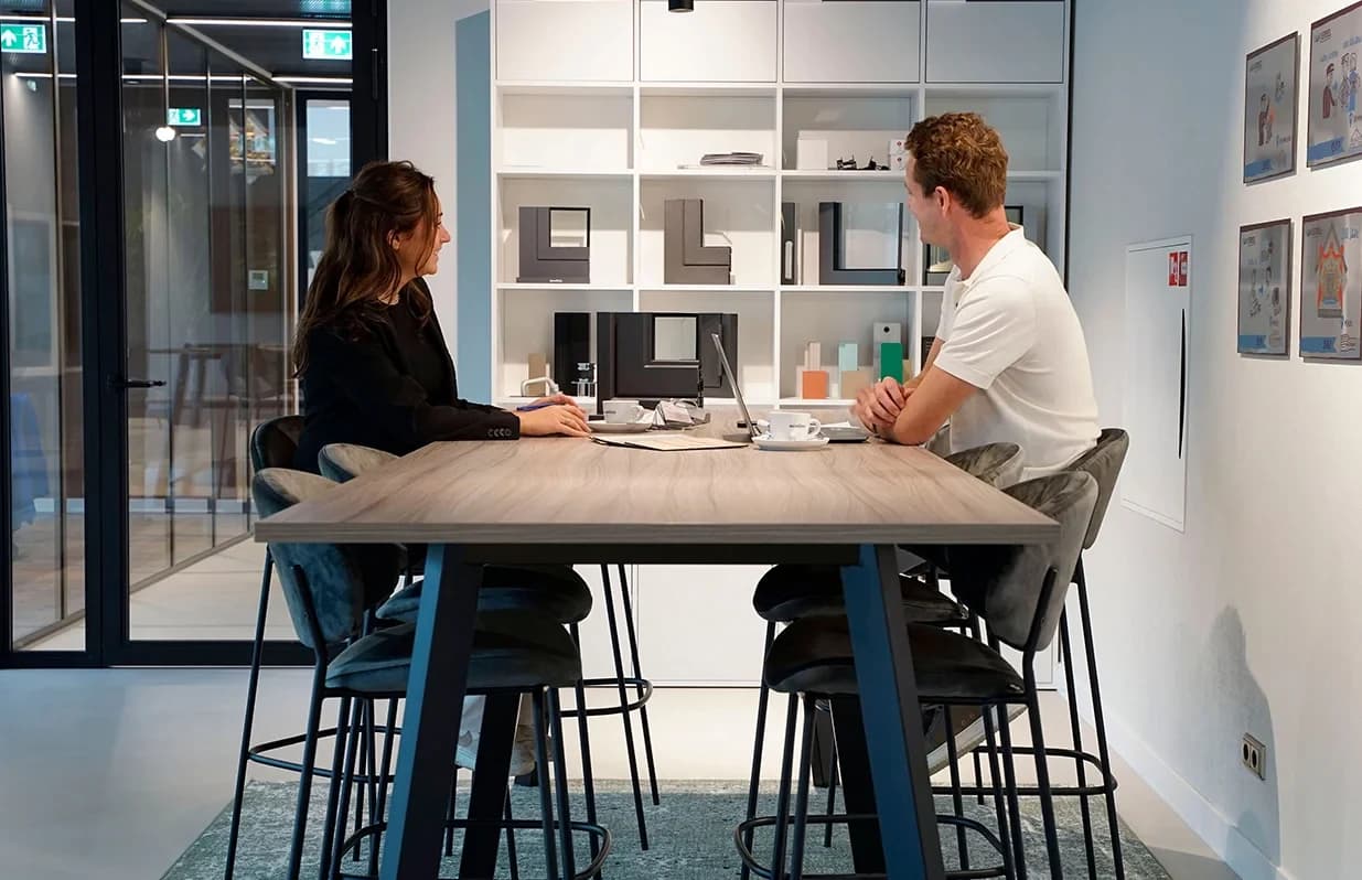 Een adviesgesprek bij Van Iersel met gevelprofielen en materiaalmonsters op de achtergrond